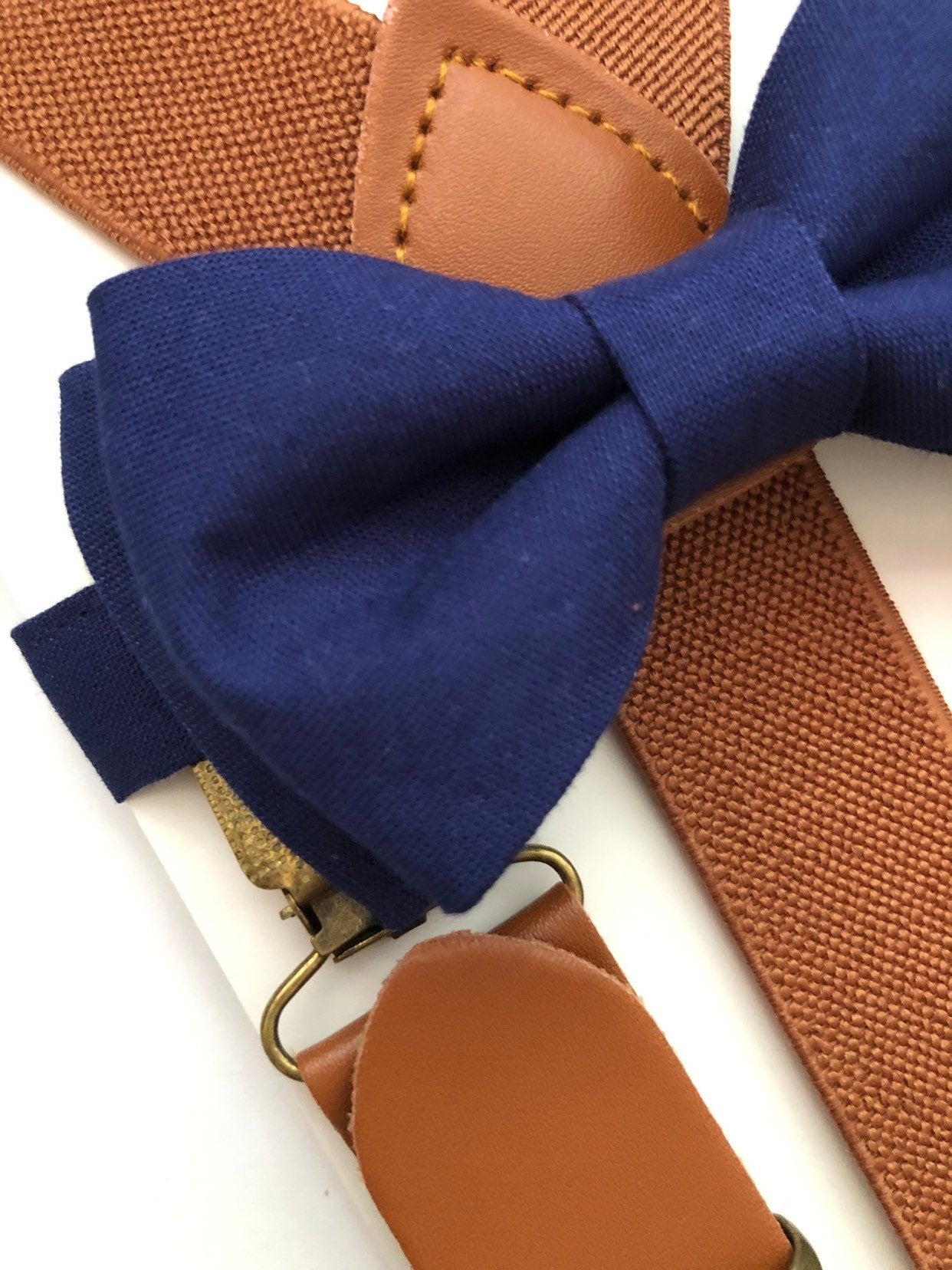 Brown Elastic Buckle Cognac Suspenders and Navy Blue Bow Tie.